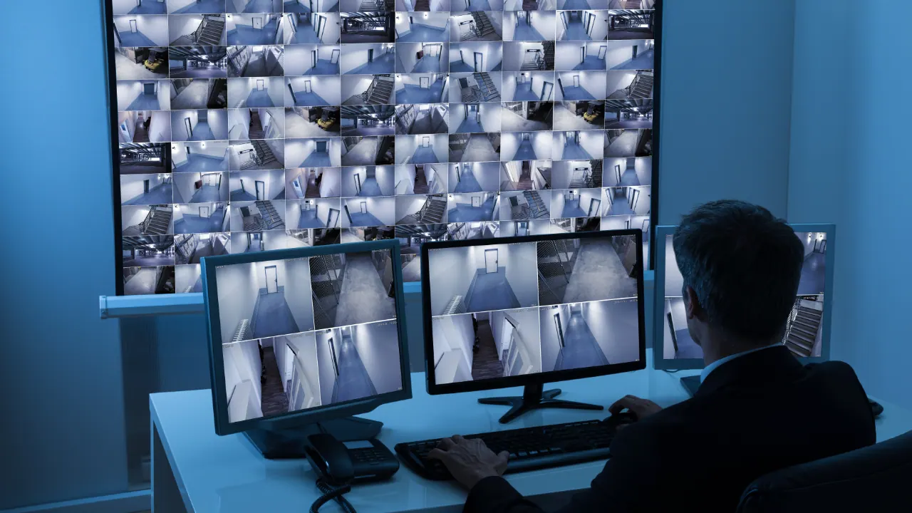 Operator viewing security camera feeds in a control room