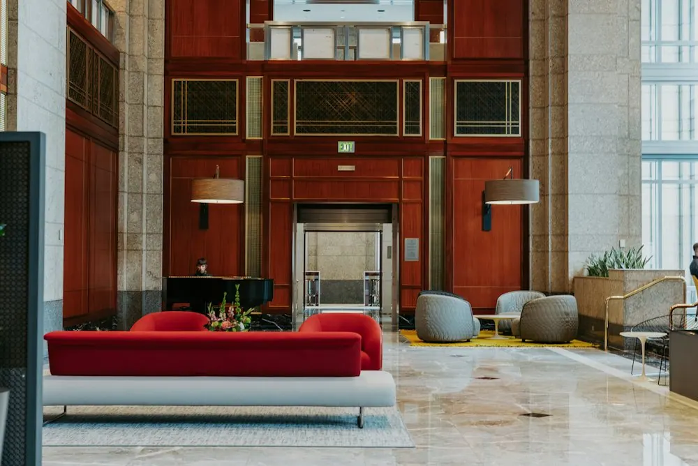 Hotel lobby with seating, a piano and a lift