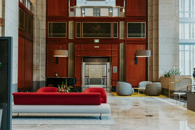 Hotel lobby with seating, a piano and a lift
