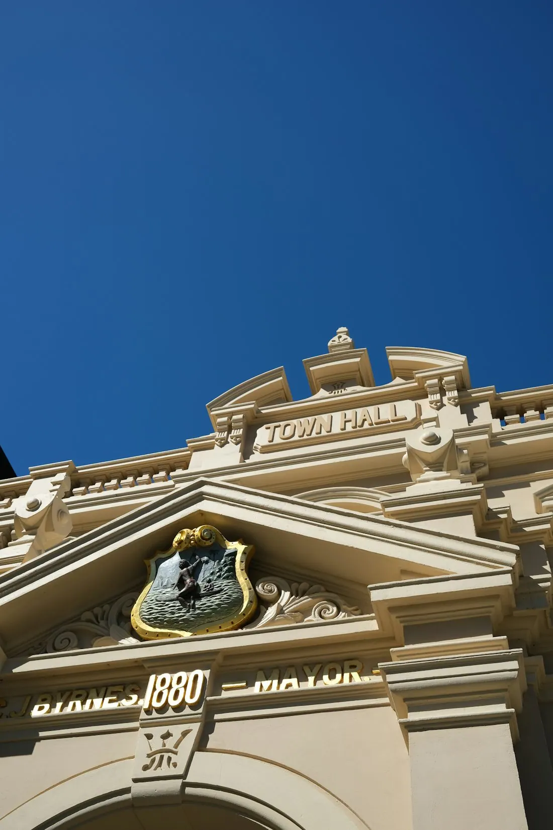 Town hall entrance and stone facade beneath a blue sky