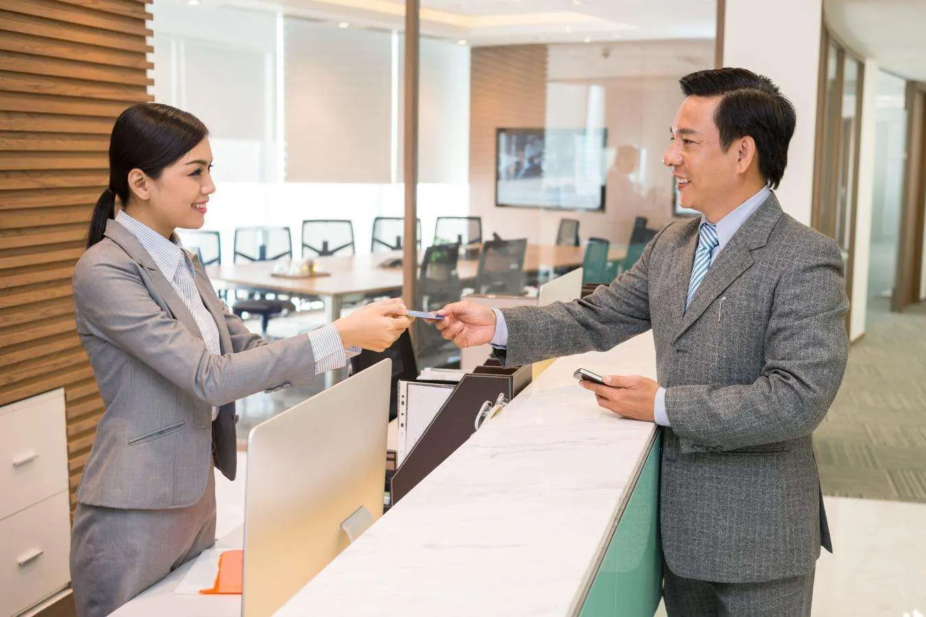 Visitor being welcomed at a reception desk