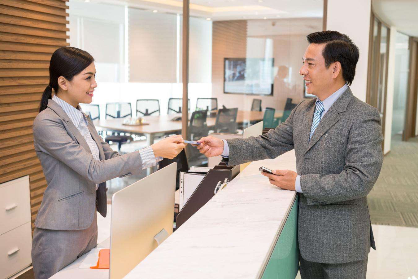 Visitor being welcomed at a reception desk